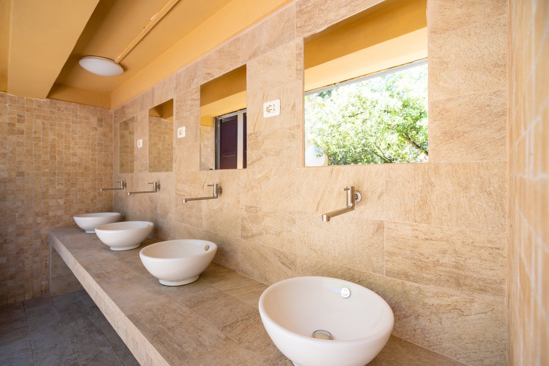 Lavabi dei servizi igienici comuni del Camping Enfola curati e luminosi