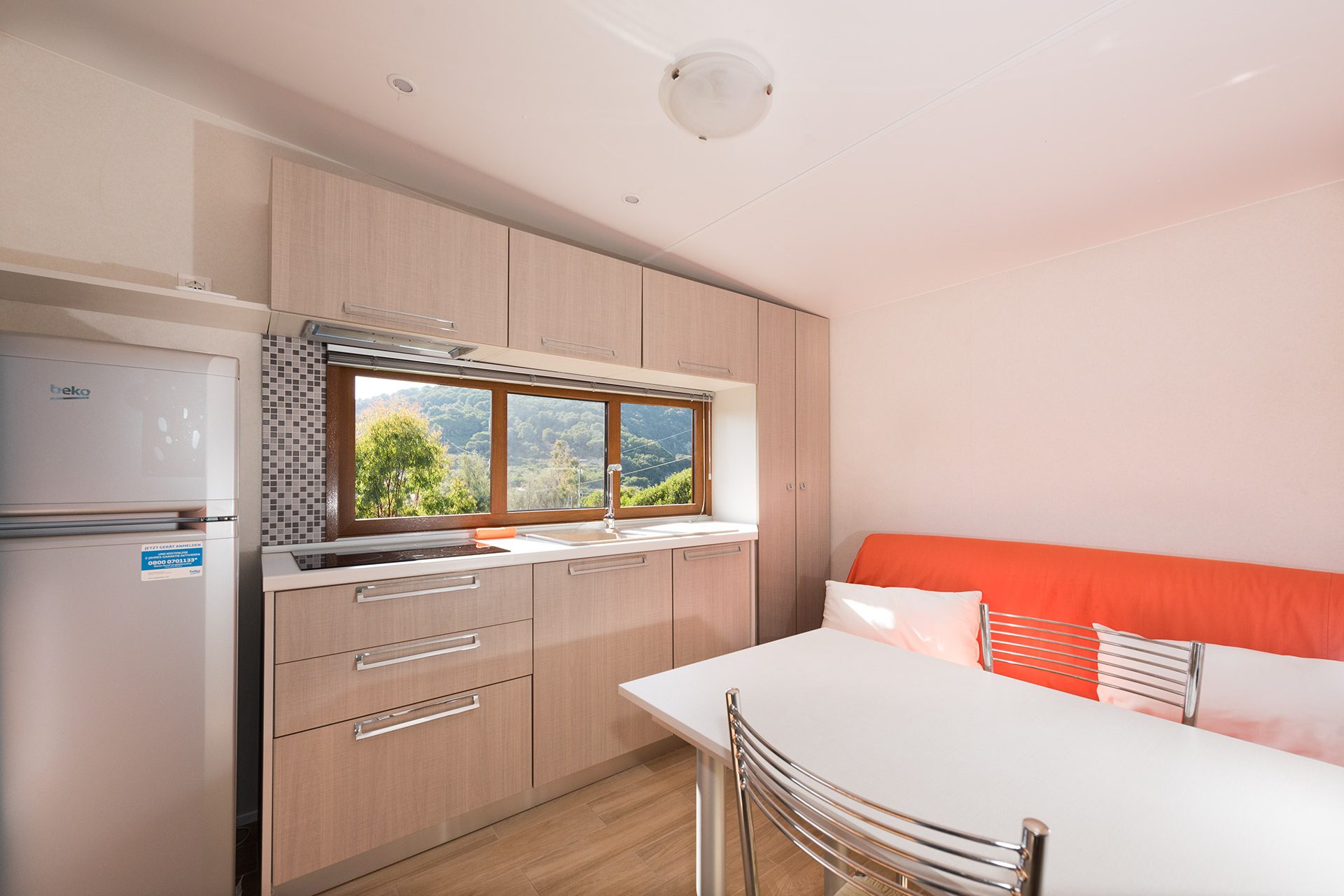 Area pranzo interna con cucina del Camping Enfola