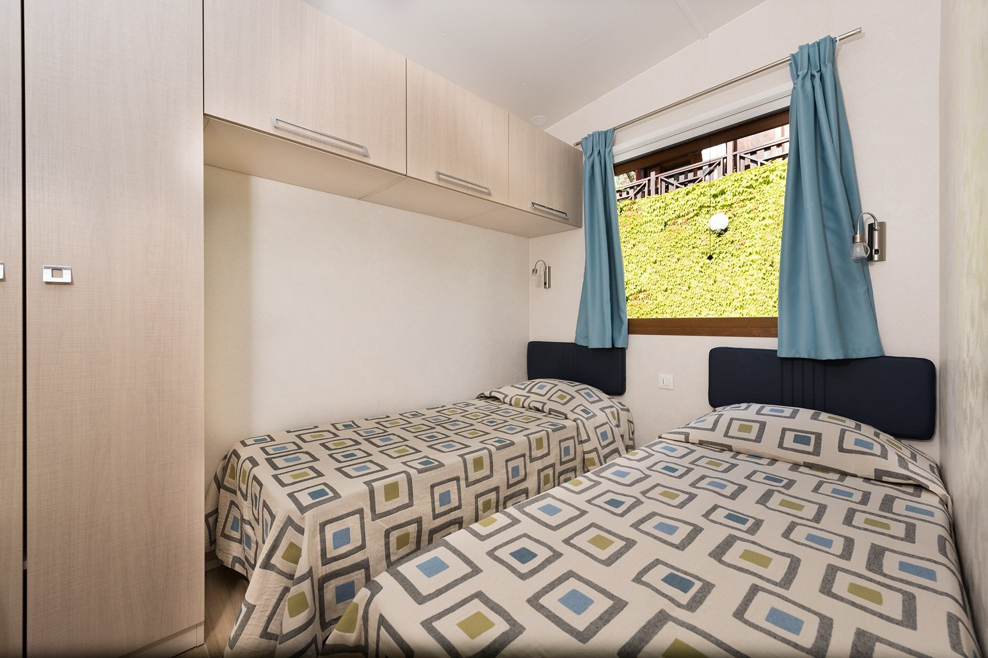 Camera doppia con letti singoli in uno chalet del campeggio