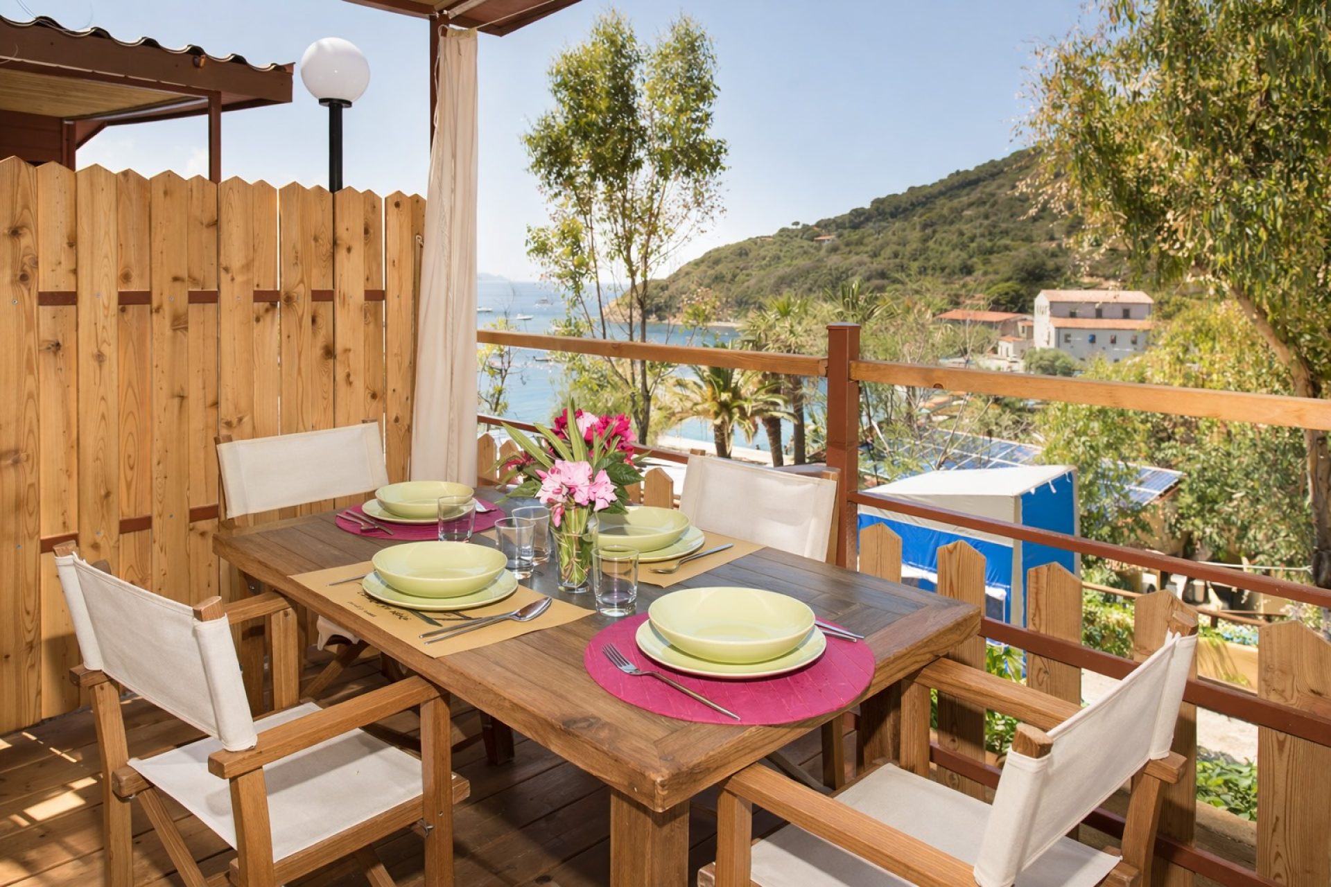Zona pranzo all’aperto in veranda immersa nel verde