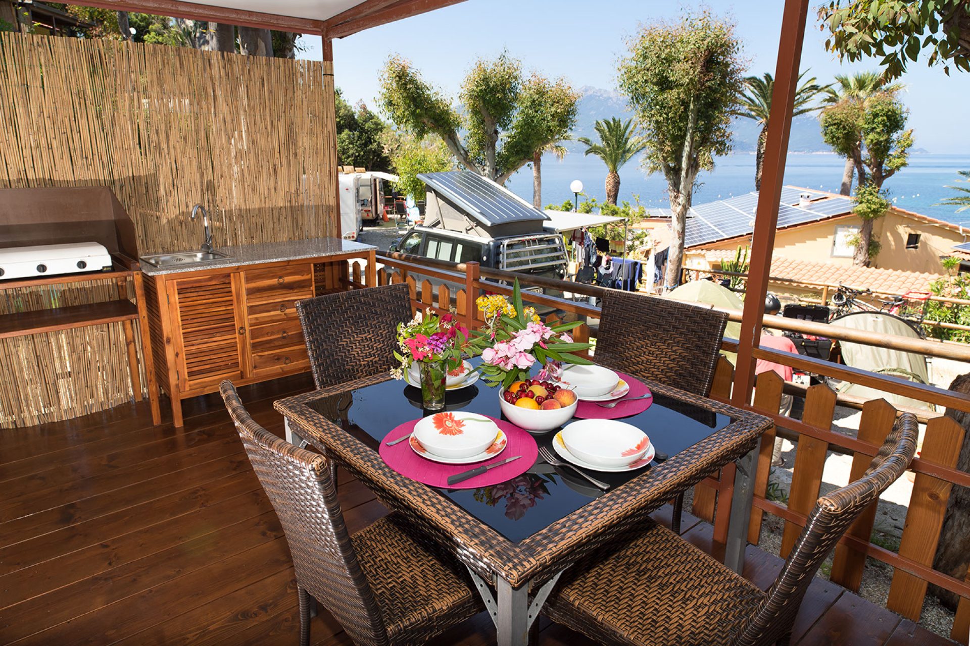 Veranda arredata con tavolo e sedie davanti a un bungalow