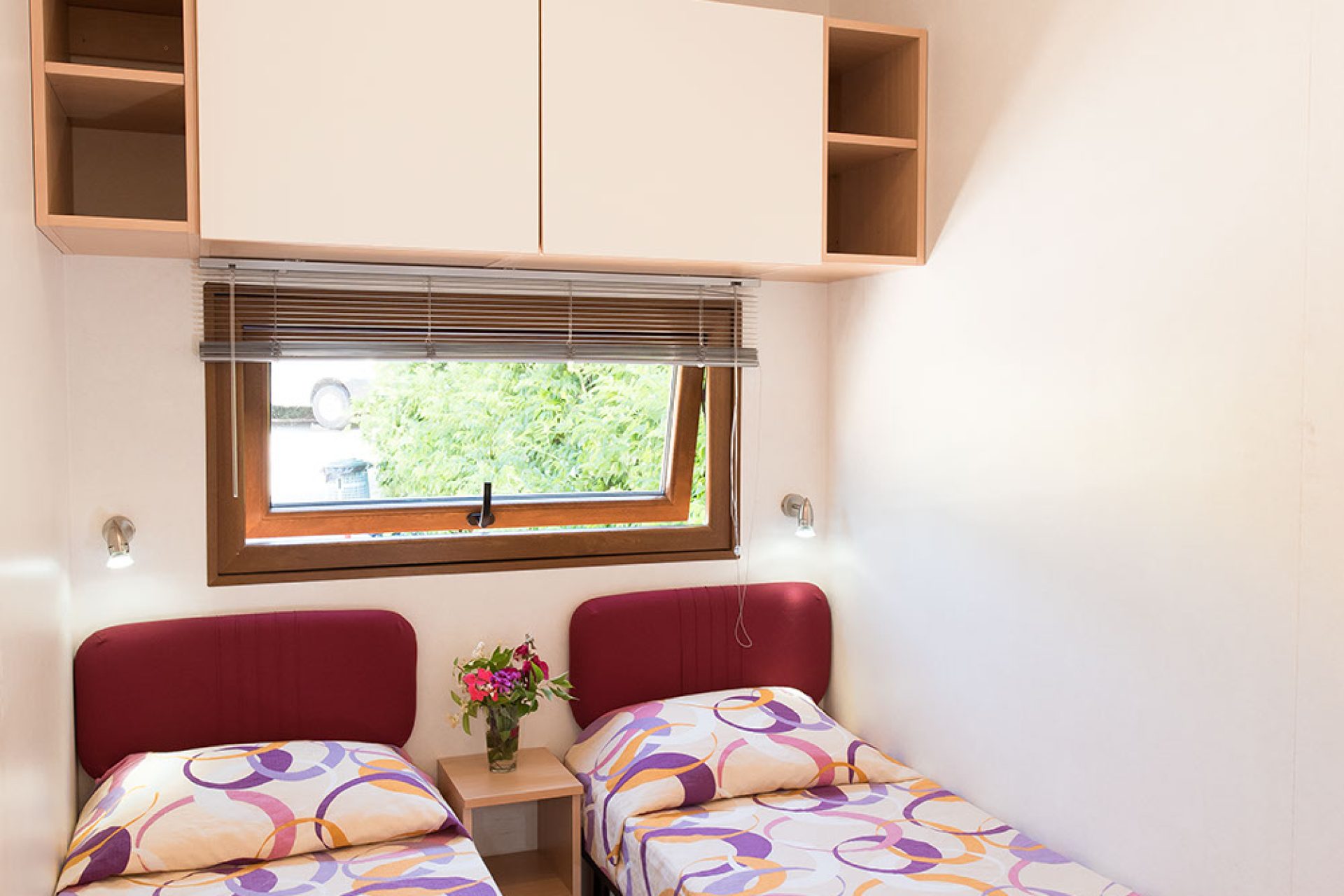 Camera con letti singoli all’interno di un bungalow del campeggio