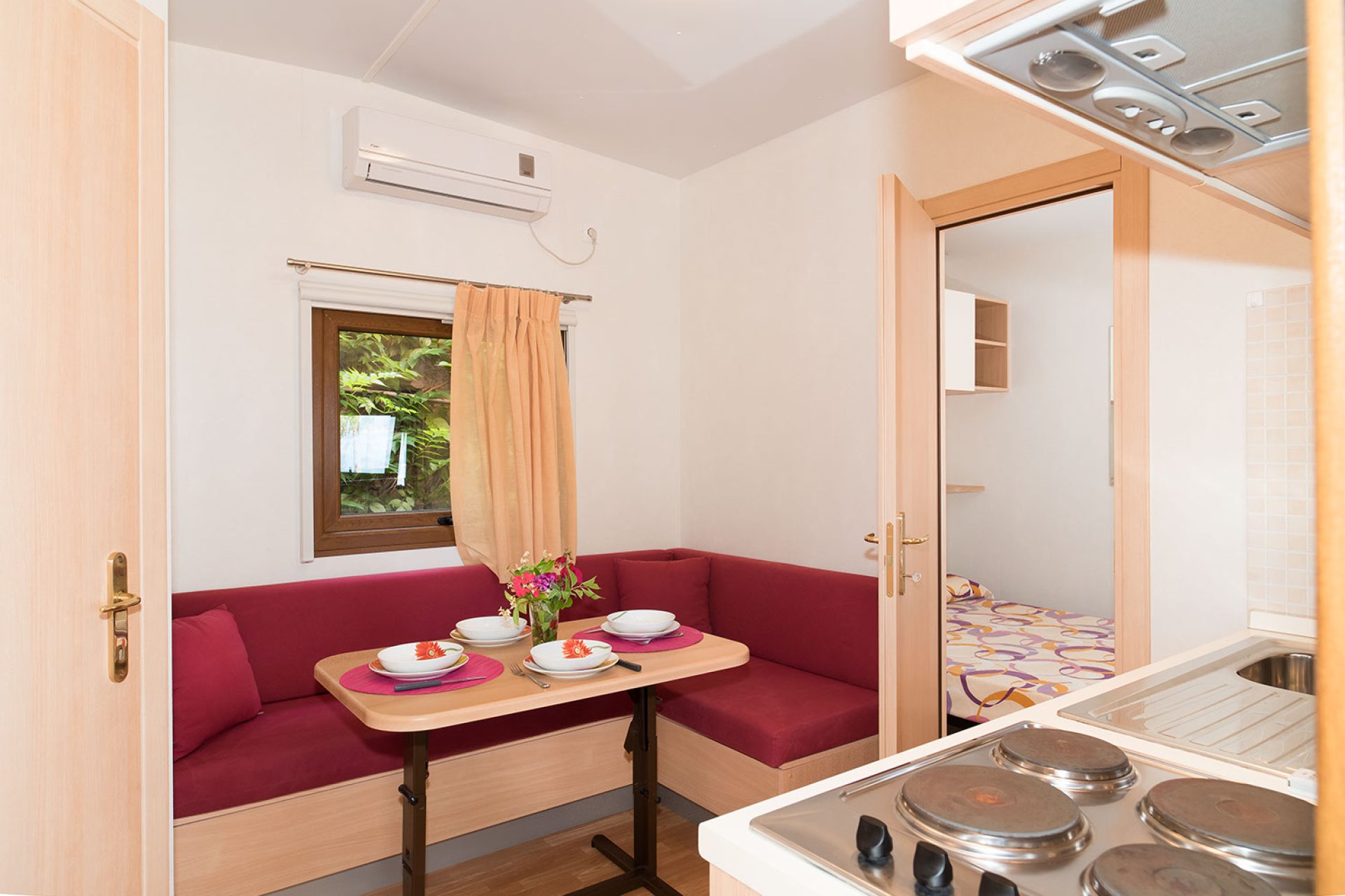 Zona giorno con angolo cottura in bungalow del campeggio